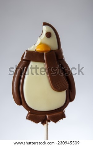 chocolate lolly pop in the shape of a penguin shot in the studio being eaten