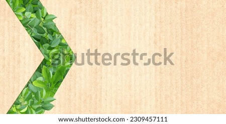 Green leaves and arrow symbol on recycled cardboard texture . Horizontal banner with eco paper texture. Paper background. Recycled carton material. Ecology and zero waste concept. Copy space for text Royalty-Free Stock Photo #2309457111