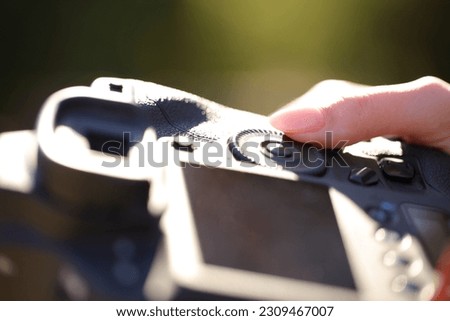 Close up portrait of a photographer finger setting diaphragm aperture on camera dial Royalty-Free Stock Photo #2309467007