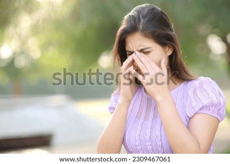 Allergic woman scratching eyes in summer in a park Royalty-Free Stock Photo #2309467061