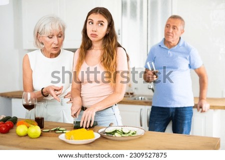 Mother-in-law teaches young daughter-in-law to cook dinner in the kitchen Royalty-Free Stock Photo #2309527875