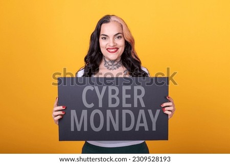 Beautiful woman pointing at a Cyber Monday sign