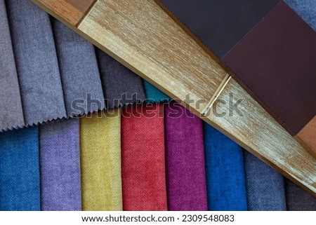 A colorful set of cozy fabric samples and rustic stain finished timber color samples 