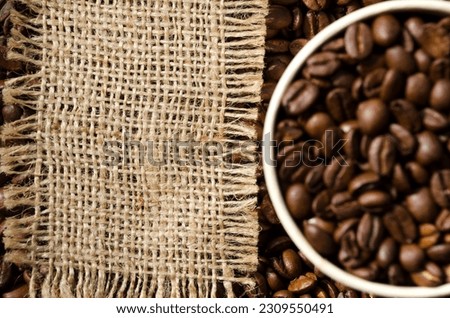 Coffee beans in a paper glass on a black background. Photo for advertising a coffee shop. Menu of coffee drinks.