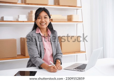 Photo of asian business woman writing notes in workplace