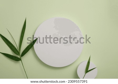 Blank template design stand on round white podium presentation with green leaves. Beauty product extracted from activated bamboo charcoal may benefit the skin in several ways