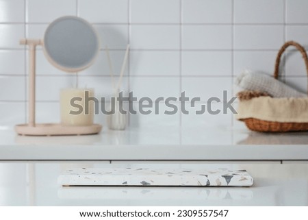 Scene for advertising and branding cosmetic product with bathroom concept - empty marble podium to place your design, mirror, toiletries on bamboo basket and scented candles decorated on tile wall Royalty-Free Stock Photo #2309557547