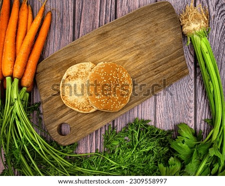 Burger on wooden board top view from above wooden background surrounded by ingredients. Whole series show adding one components on each picture. 