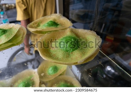 Kue ape or serabi Jakarta is a popular traditional pancake with soft and fluffy center surrounded with thin and crispy crepes, commonly found as a popular street food in Indonesia.  Royalty-Free Stock Photo #2309584675