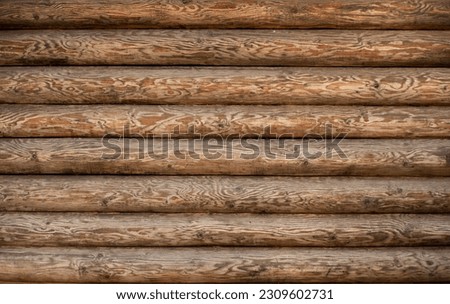 Background of a wooden wall of a house made of a round beam