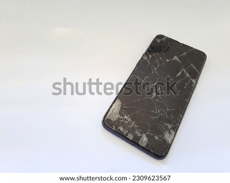 black smartphone with a broken screen isolated on white background