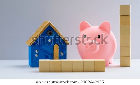 Piggy bank, coins,  and calculator with a wooden house  Concept of financial, savings, investments, insurance