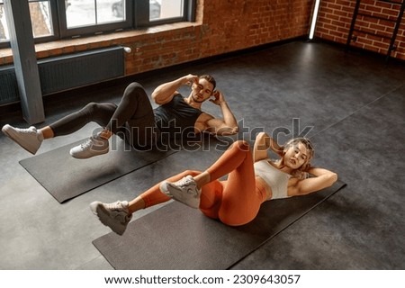 Man and woman doing abs exercise at group training class Royalty-Free Stock Photo #2309643057