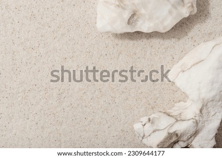 Natural cosmetic background for product presentation. White rocks on the sand. Top view. Royalty-Free Stock Photo #2309644177