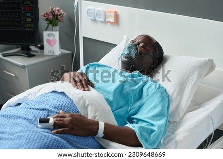 Man in oxygen mask lying in hospital Royalty-Free Stock Photo #2309648669