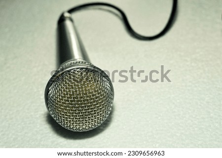Gray metal microphone for amplifying sound and voice on a white background close-up