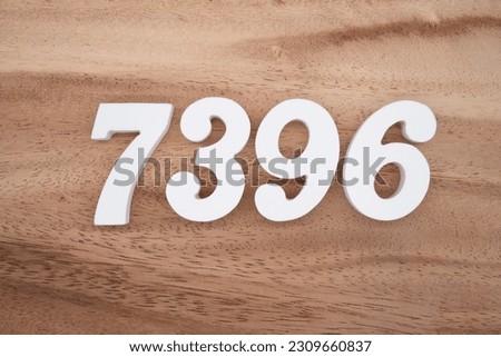 White number 7396 on a brown and light brown wooden background.