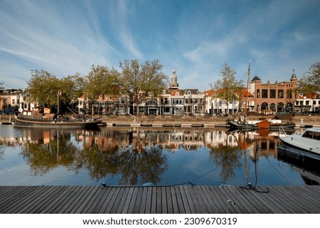 view of the west side of the old harbor in Vlaardingen. The tower of the Grote Kerk is visible in the center of the picture. Westhavenkade, canal Royalty-Free Stock Photo #2309670319
