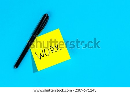 Yellow note with word Work and marker on blue background, flat lay.