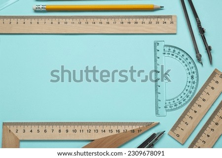 Flat lay composition with different rulers and protractor on turquoise background. Space for text