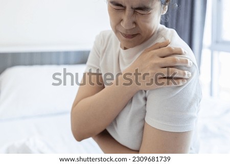 Asian middle aged woman suffering from shoulder pain,shoulder dislocation,aching numbness and weakness,tired female patient with Dislocated shoulder joint,discomfort caused by illness or injury Royalty-Free Stock Photo #2309681739