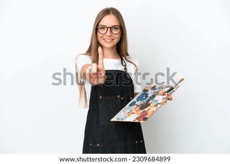 Young artist Lithuanian woman holding a palette isolated on white background showing and lifting a finger