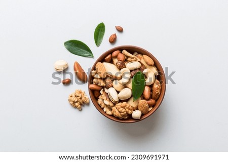 mixed nuts in bowl. Mix of various nuts on colored background. pistachios, cashews, walnuts, hazelnuts, peanuts and brazil nuts. Royalty-Free Stock Photo #2309691971