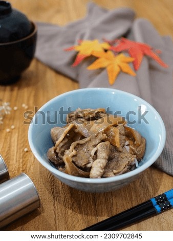 gyudon or Japanese dish consisting of a bowl of rice topped with beef and onion simmered in a mildly sweet sauce flavored with dashi (fish and seaweed stock), soy sauce, red gingger and chili. 