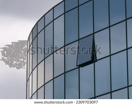 Close-up photo of a modern glass business building with an open window