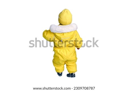 Happy toddler baby in winter clothes snowsuit isolated on a white background. A child in a warm yellow jumpsuit with a hood. Kid aged one year five months Royalty-Free Stock Photo #2309708787