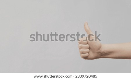Like gestures. Perfect choice. Female hand showing thumb up on light gray background copy space.