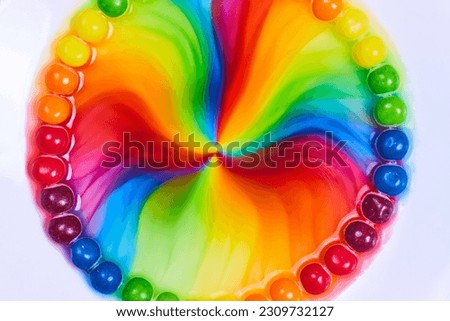 Rainbow circle in water inside ring of skittles candy