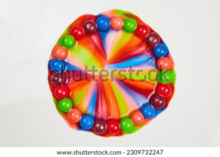 Circle or gateway of skittles sugar candy on white background with rainbow effect from water