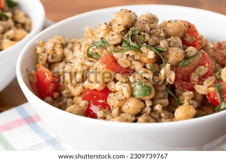 Bowl of delicious spelt salad with chickpeas and vegetables, vegetarian food  Royalty-Free Stock Photo #2309739767