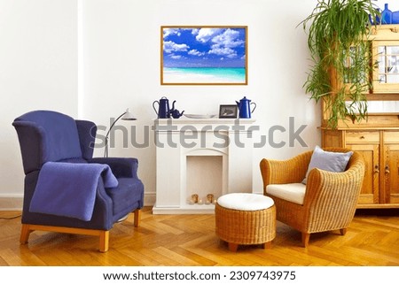 Custom-made home decoration concept: living room with a wing and a wicker chair and a framed photo print of a beautiful caribbean beach scene.