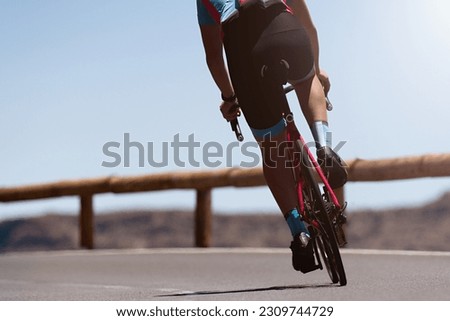 Male cyclist riding racing bicycle, man cycling on countryside summer road. Training for triathlon or cycling competition
