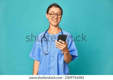 Caucasian young nurse talking on phone, studio photo.