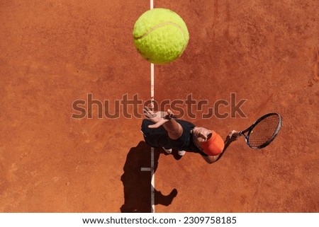 Top view of a professional tennis player serves the tennis ball on the court with precision and power Royalty-Free Stock Photo #2309758185
