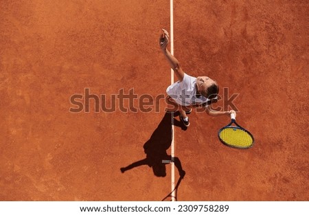 Top view of a professional female tennis player serves the tennis ball on the court with precision and power Royalty-Free Stock Photo #2309758289