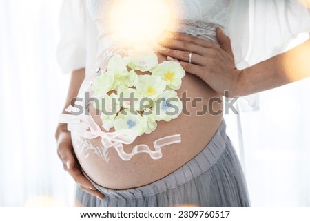 Close-up of a pregnant woman's belly with art to commemorate her pregnancy