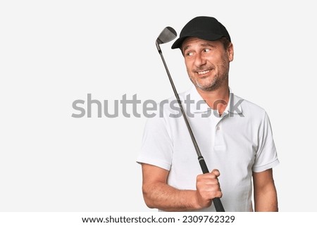 Middle aged golfer man looks aside smiling, cheerful and pleasant.
