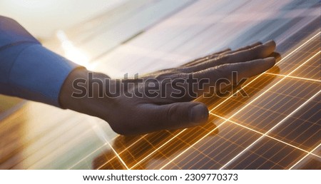 Close Up on Hand Of Professional Maintenance Engineer Touching Industrial Solar Panel Generating Electricity. VFX Graphics Edit Visualizing Energy Being Generated. Green Energy Concept.