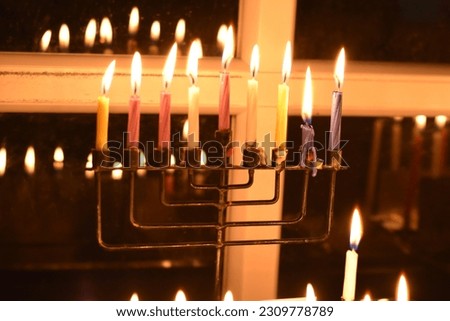 Hanukkah candles in wax candles with beautiful reflections in the window