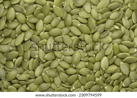 Green pumpkin seeds background. Top view. Flat lay. Texture element for package and marketing materials design
