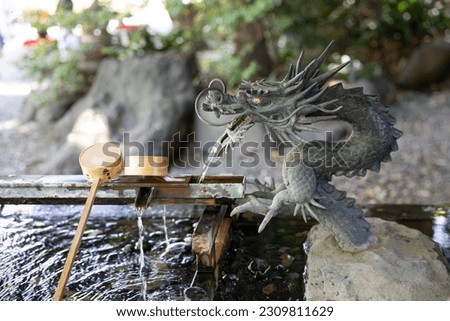bamboo water ladle dipper on the pond and stone dragon fountain. Usually see in front of the temple and shrine in Japan. For cleaning hands and mouth before pray god.