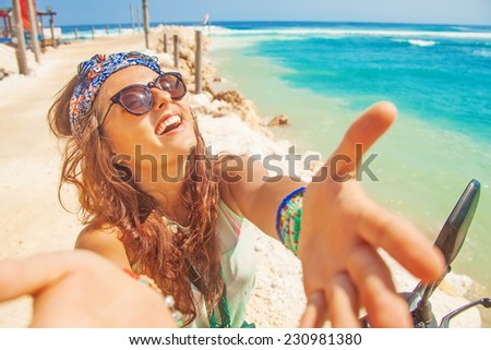stylish selfie with own mobile phone on a beach while riding a motorbike