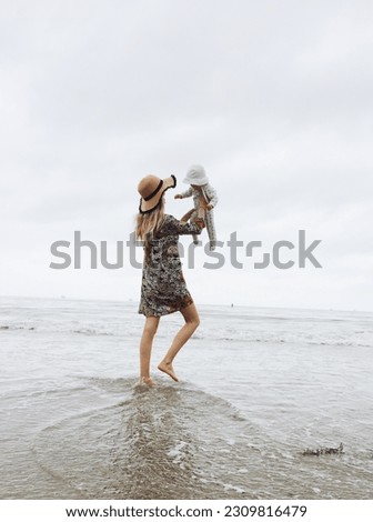 Mother and daughter on the beach in california on a gloomy day.