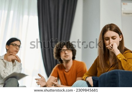Young couple during counseling session with psychotherapist. Focus on the woman in despair and frustration. Misunderstanding in relationship Royalty-Free Stock Photo #2309845681