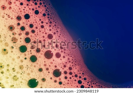 thick bubbling soap suds on the surface of the water. Beautiful bright, trendy colors, gradient. Macro. Texture of soap bubbles, foam. Texture background, desktop wallpapers