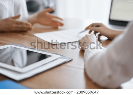 Business people discussing contract signing deal while sitting at the wooden table in office. Partners or lawyers working together at meeting. Teamwork, partnership, success concept